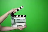 Hands holding a clapperboard for a movie production
