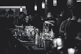 A black and white photo of a crowded bar