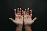 Photo Of Person’s Open Hands on a dark background