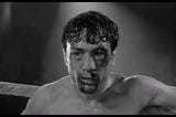 Jake DeMotta beaten bloody and barely holding it together on the ring from the movie Raging Bull