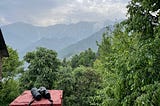 A pair of binoculars on a red-brick pillar of a house overlooking the Dhauladhars, Himalayas