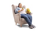 overweight woman in an armchair drinking soda and eating chips