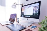 macbook, laptop, and iphone desk setup