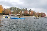 3 guys in kayaks on a lake