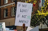 Photo of a board for the climate saying if not us who? If not now when?