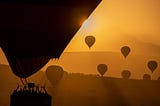 Sunrise in Cappadocia with hot air balloons in silhouette