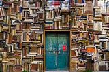 Rows upon rows of haphazardly arranged books, with a blue rusted door in the middle
