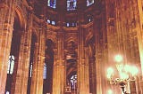 The inside of a Parisian cathedral softly lit in the evening