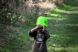 child wearing a bucket on their head. what if normal is the illusion?