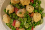 The peas and dumplings on a dinner plate.