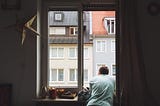 A man leans out of a sliding window in Munich.