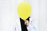 Person with balloon over their face.