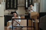 Woman sitting on floor assembly a small table.