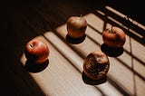 4 apples in a circle, the one on the left at 9pm looking healthy, the one on 12 and 3pm sligthly unpleasant and the apple at 6pm rotten and decomposing.