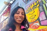 Bukht smiling in front of Mexican street art.