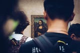 Mona Lisa painting in Louvre with a lot of people in front of it.