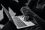 Black and white photo of someone on a laptop