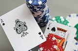 blackjack cards next to stacked casino chips