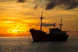 A freighter anchored at sunset