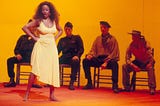 Denyce Graves as Carmen in the 1991 production. Standing proudly in a long yellow dress in front of soldiers.