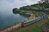 File: VL 85–022 container train.jpg English: BoBoBo+BoBoBo VL85 class AC electric locomotive VL85–022 with a container train on the coast of Lake Baikal, Trans-Siberian Railway: the stretch between Utulik-Slyudyanka. Author Sorovas This file is licensed under the Creative Commons Attribution-Share Alike 3.0 Unported license. https://creativecommons.org/licenses/by-sa/3.0/deed.en https://commons.wikimedia.org/wiki/File:VL_85-022_container_train.jpg