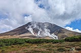 Mountain with fumaroles rising like steam vents