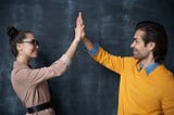 A man and woman high-fiving.