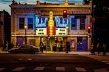 Exterior of lit-up Bluebird Theater at dusk, Colfaxe Ave. in Denver.