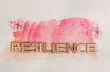 the word Resilience spelled out in gold letters with pink water mark in the background