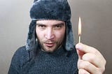 guy in winter hat with lit match