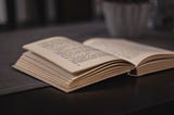 An open book lying face-up on a table