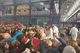 Butcher selling an entire leg of pork at a crowded event in Smithfield Market.