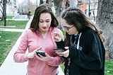 Two women looking at their smartphones