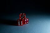 Picture of three red dice against a dark blue background.