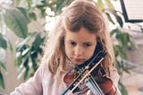 A young girl is playing the violin