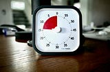 A square egg timer with a red section marking out fourteen minutes.