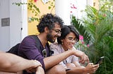 Two people outside happily using their smartphones to view a mobile website.