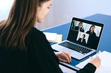 professional individual in an interpreting meeting on a laptop