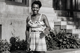 Black and white photo of a Black young woman in the fifties wearing a summer dress.