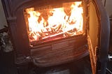 A fireplace stove burns a fire.