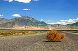 Tumbleweed blow aimlessly down the road