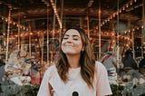 Woman in white crew neck t-shirt smiling.