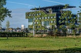 A university building that is covered in green plants