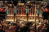 A lighted carousel ride with elaborate designs and painted ponies.