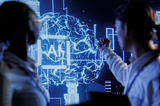 Two professionals analyzing a digital holographic brain with AI text overlay, representing artificial intelligence and data-driven innovation in manufacturing.