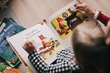 Overhead photo of a woman reading a book with her child