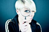 Picture of a woman looking through a magnifying glass