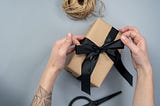 Photo of person tying a bow on a present.