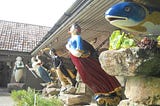 The photograph shows some of the unique and highly decoratively painted carved figureheads of fish, men and women, which were once attached to the bows of sailing ships, and which are now housed in the Valhalla collection situated within Tresco Abbey Garden, Scilly Isles.