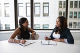 Two women sitting in an office having a technical interview